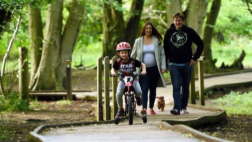 Family follow the walking trail at Hatfield Forest, Essex